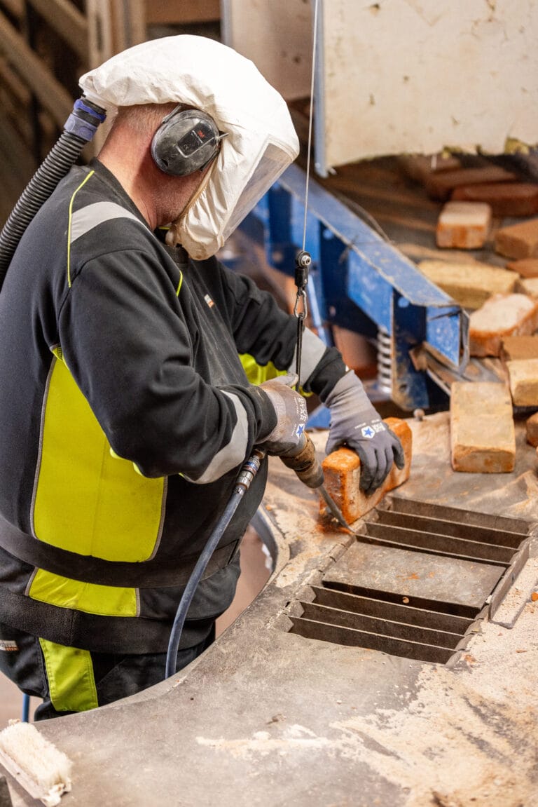 Arbejder bearbejder mursten på fabrik