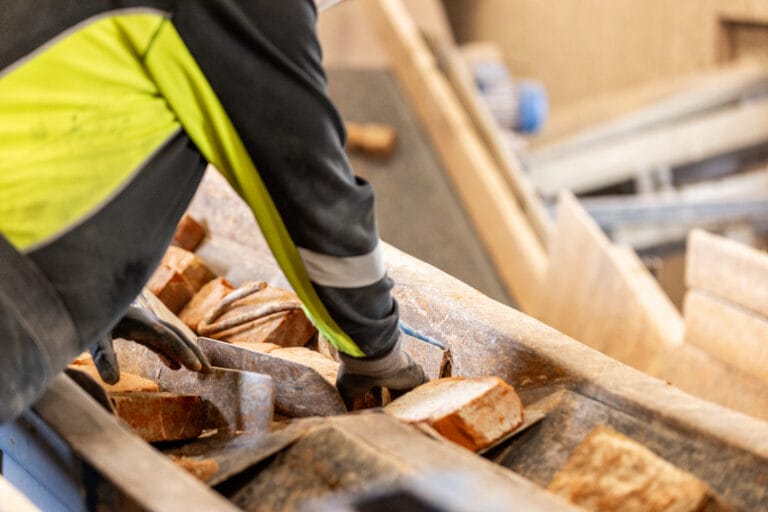Arbejder sorterer mursten på byggeplads