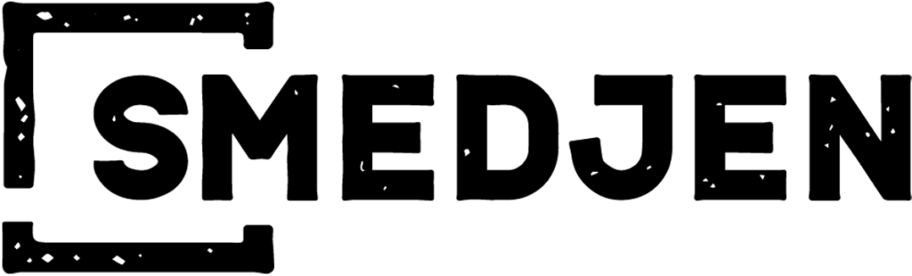 Hund sidder i græsset på solrig dag