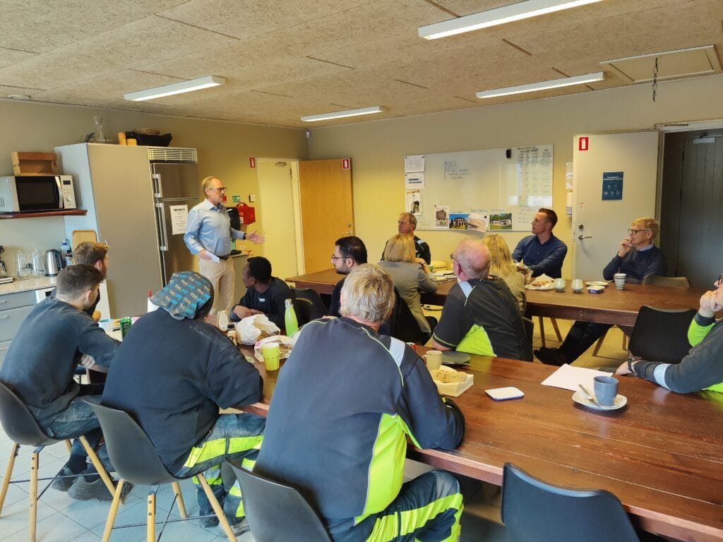 Mand holder oplæg for medarbejdere i mødelokale